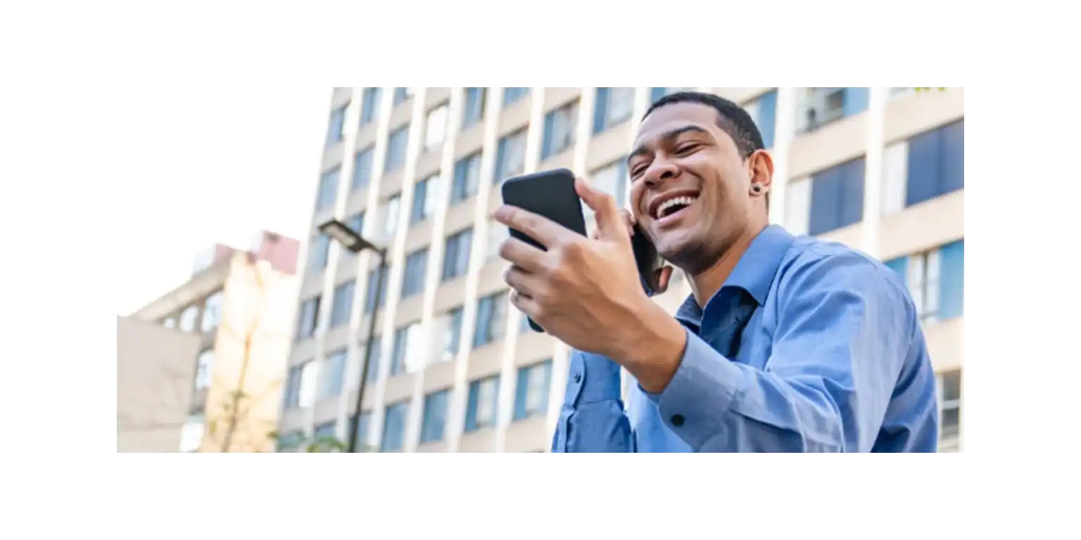 a smiling man using her phone in a cafe