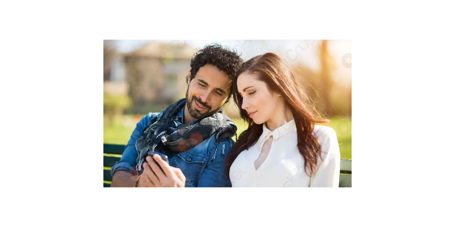 a smiling man shows something to his girlfriend on the phone's screen