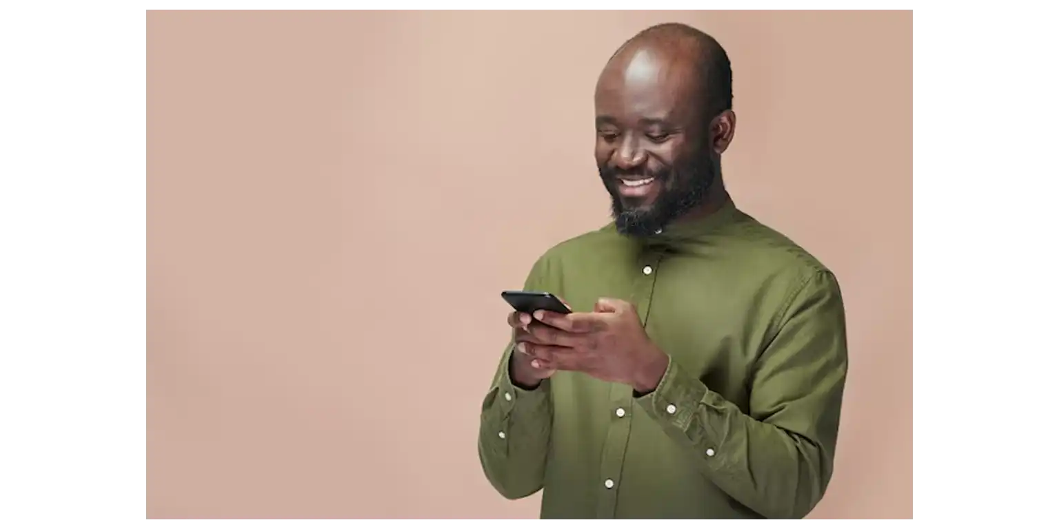 a smiling man uses his smartphone