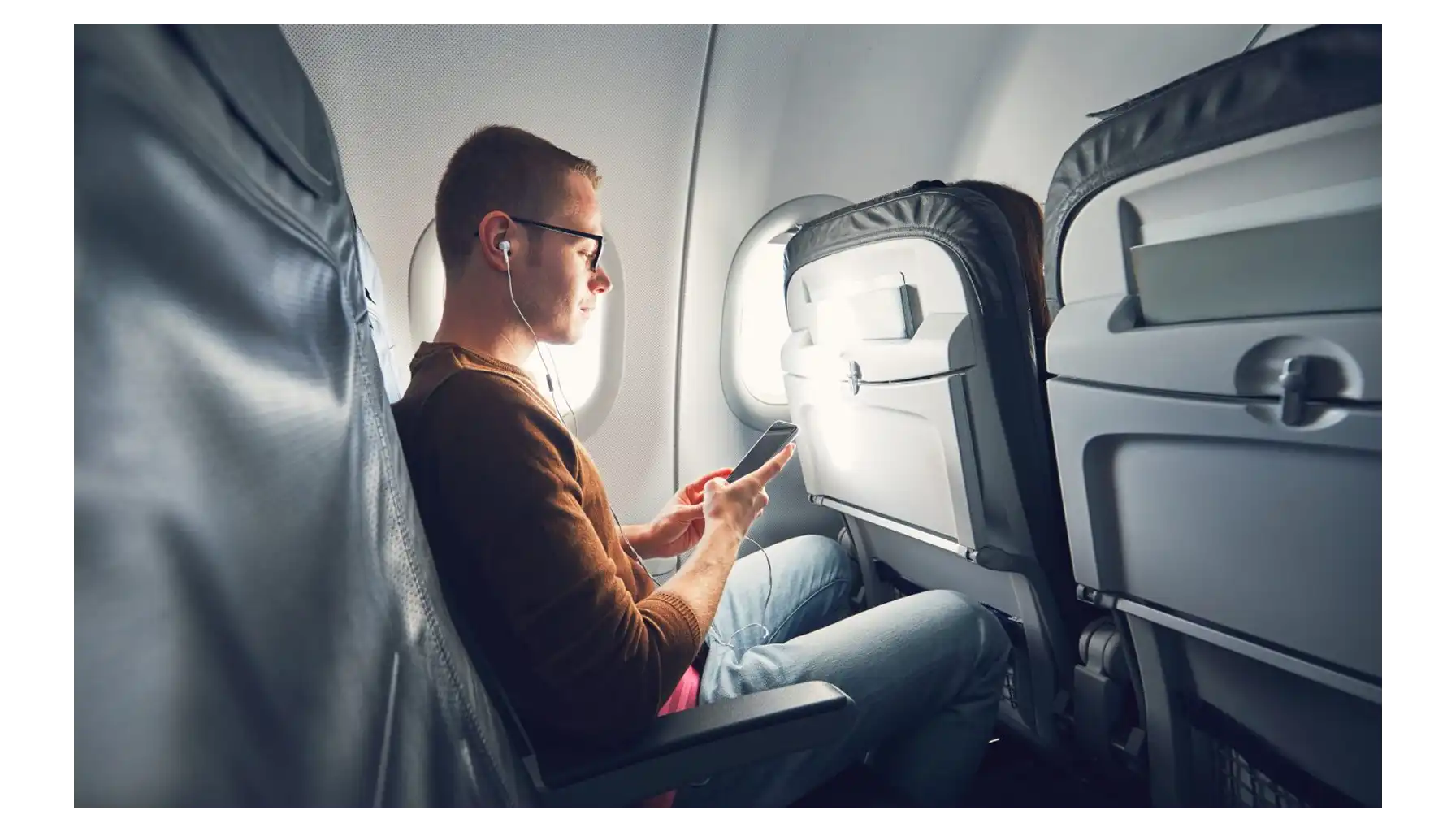 A man at the airport is texting his family that his flight was successful.